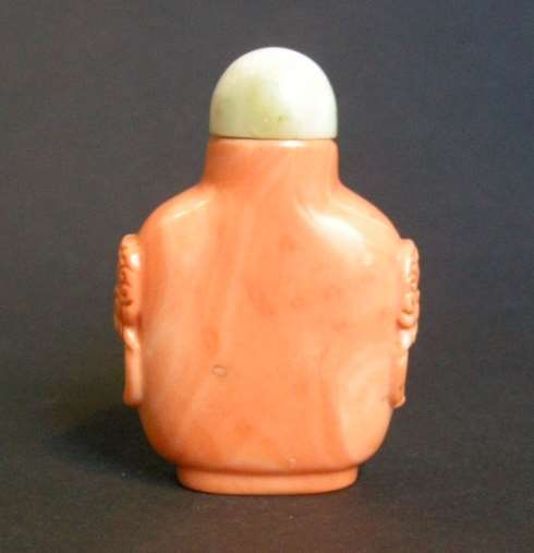 Rare coral snuff bottle sculpted with mask and ring handles